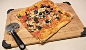 Pizza fatta in casa con una consistenza gommosa, evidenziando l'importanza della scelta della farina.
