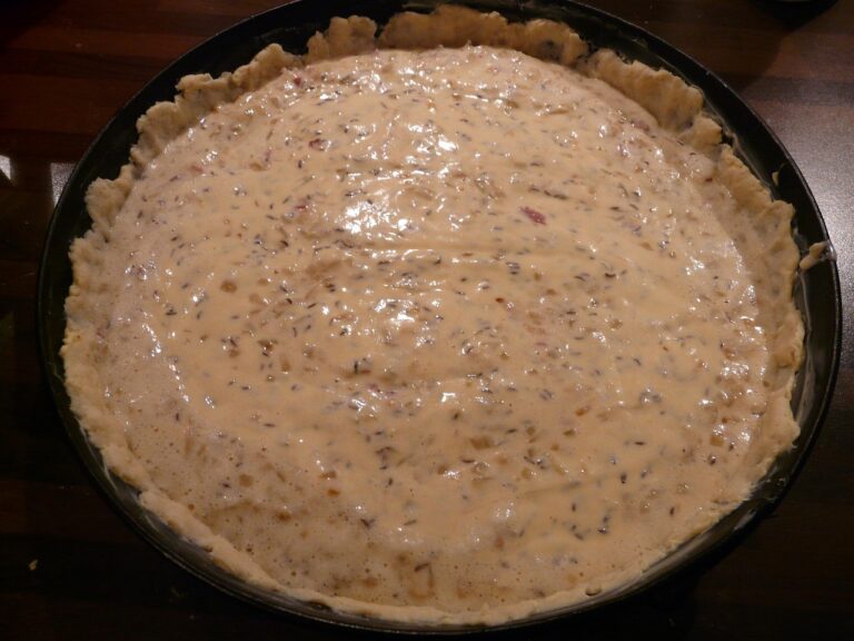 Torta salata con pasta bucherellata pronta per la cottura "in bianco" su una teglia da forno.
