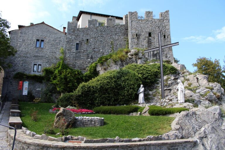Borgo di Venzone con mummie esposte e dettagli della ricostruzione storica in pietra.