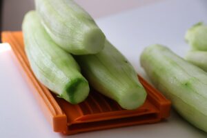 Gambi di broccoli pelati e pronti per la cottura, su un tagliere di legno.