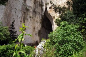 Vista panoramica della valle dei Mulini a Sorrento, con rovine e vegetazione lussureggiante che la riempie.