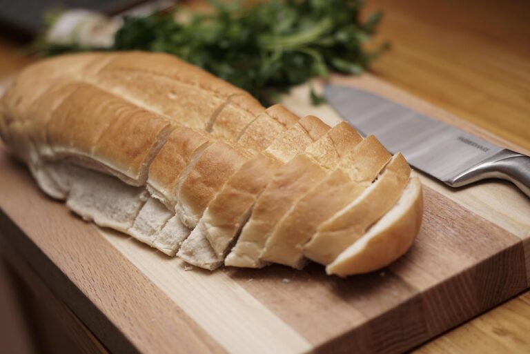 Crosta di pane in cassetta su un tagliere, pronta per essere trasformata in pangrattato o crostini.