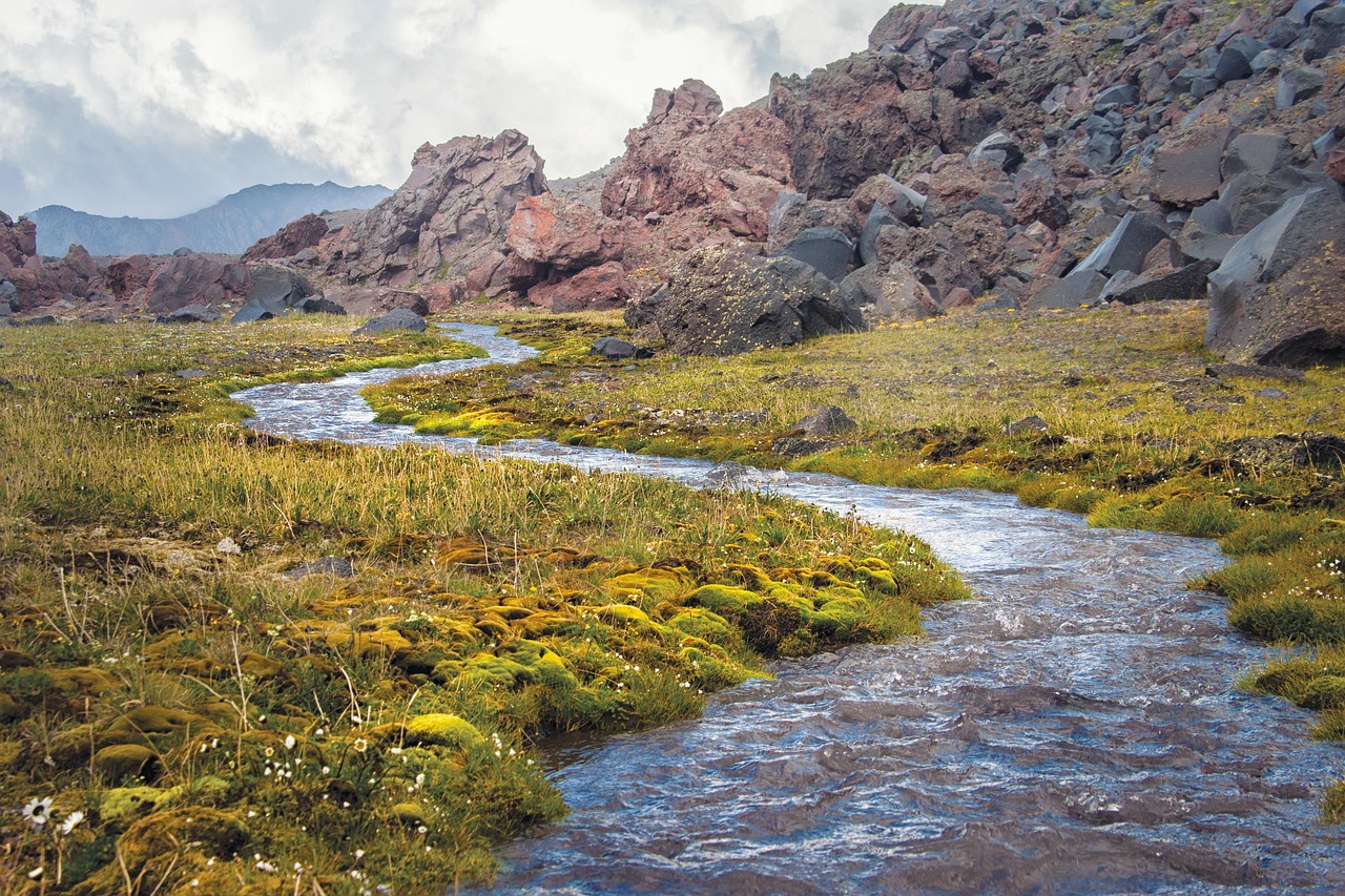 Vista panoramica delle gole dell'Alcantara con acqua cristallina tra pareti di lava nera in Sicilia.
