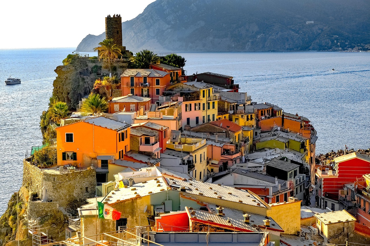 Veduta panoramica delle Cinque Terre con borghi colorati a picco sul mare, ideale per visitare senza spendere troppo.