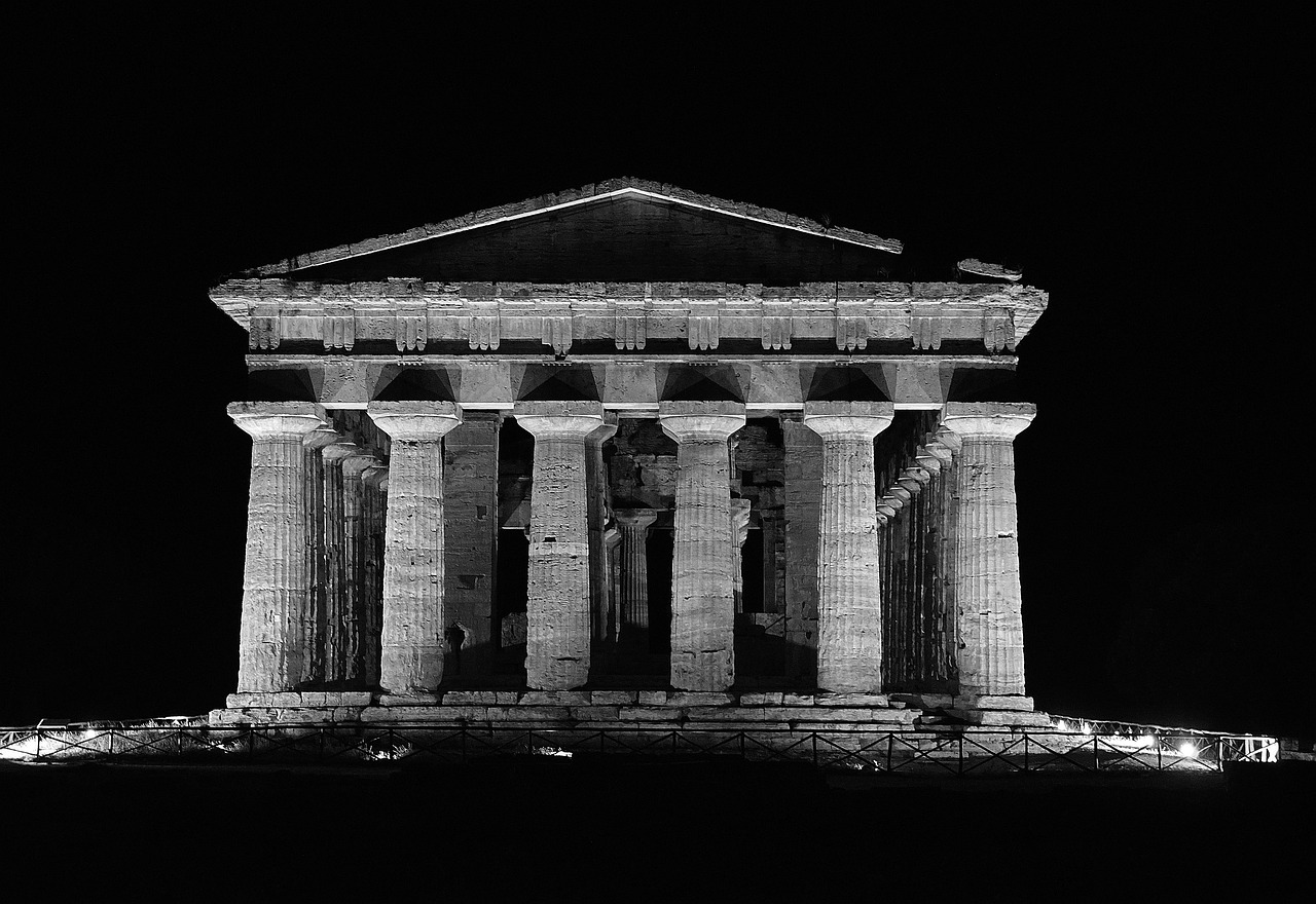 Valle dei Templi illuminata di notte, con colonne doriche che emergono sotto un cielo stellato.
