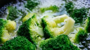 Fetta di pane imbevuta di aceto posizionata su un coperchio durante la cottura dei broccoli.